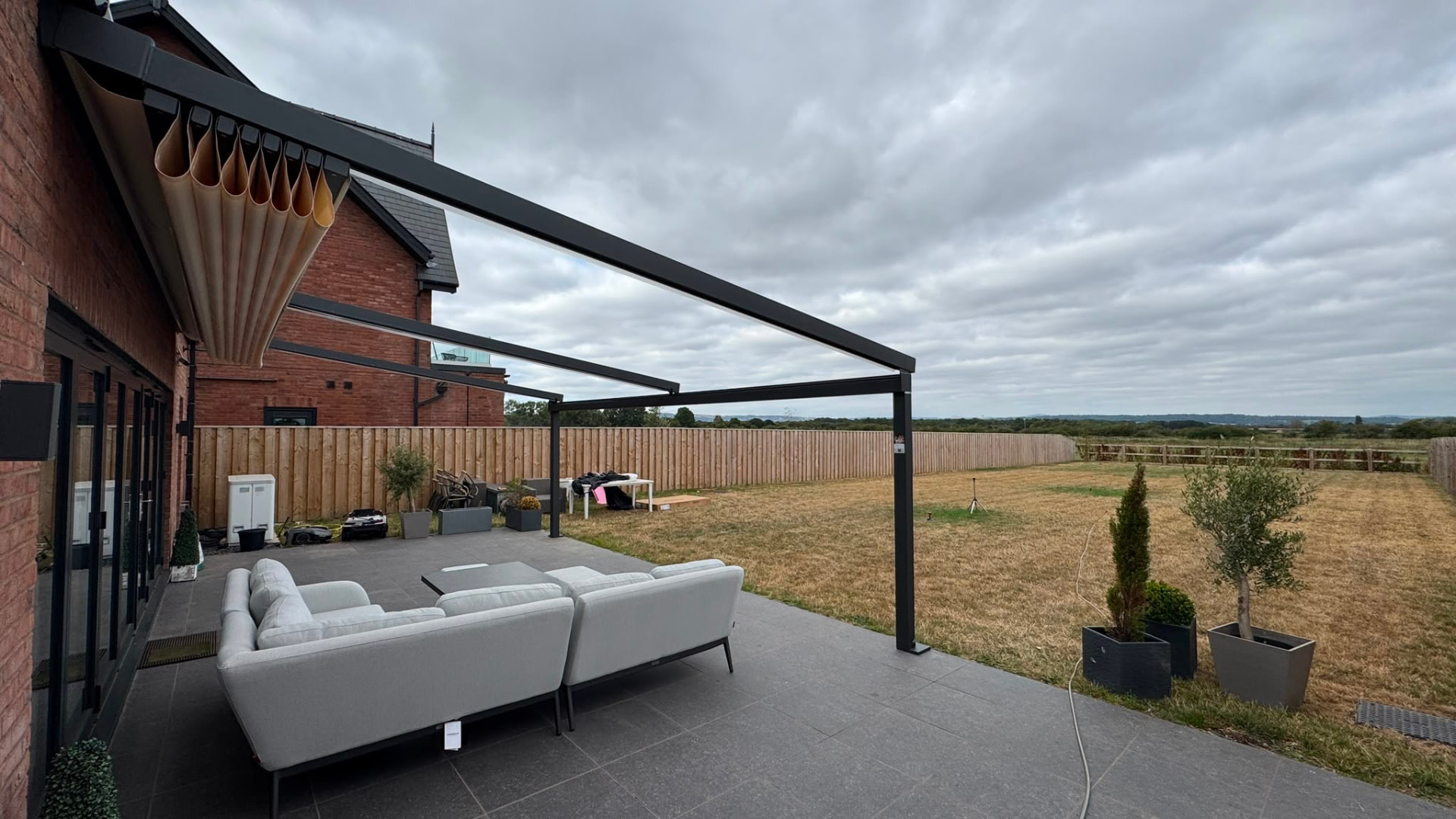 Retractable awning part folded on an aluminium patio canopy