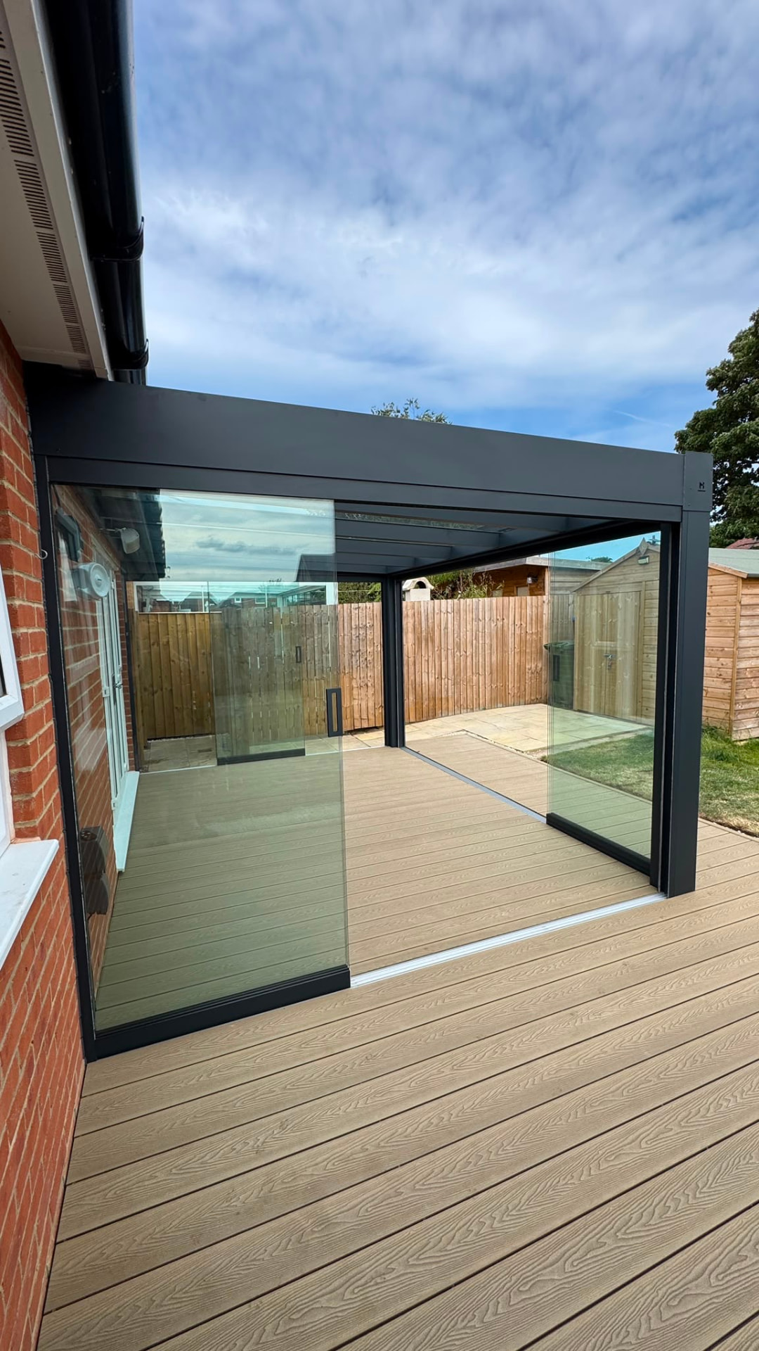 Glass room built over composite decking with sliding glass sides