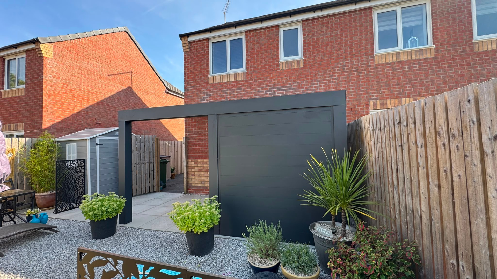 Aluminium pergola with a solid privacy wall on a small courtyard patio