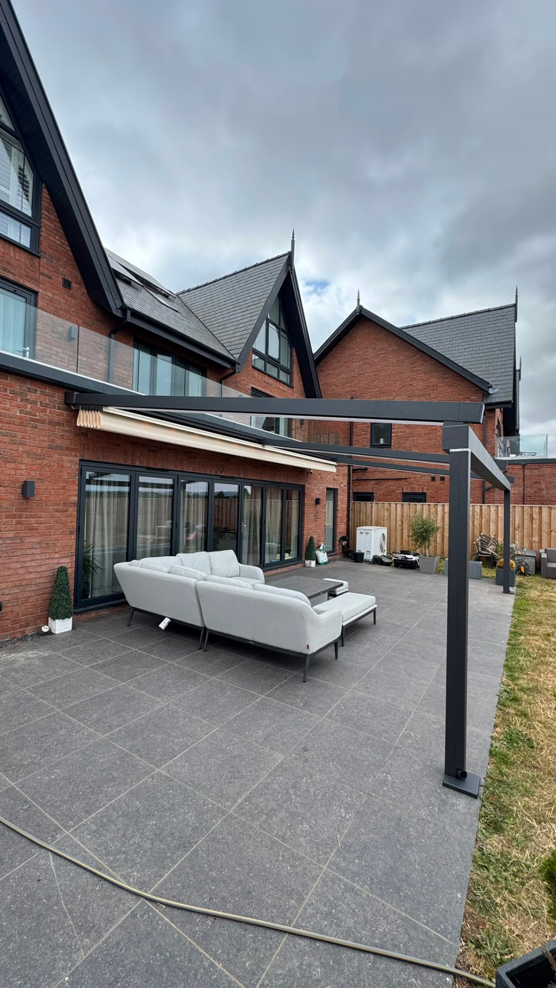 Aluminium veranda with a retractable awning above a patio seating area